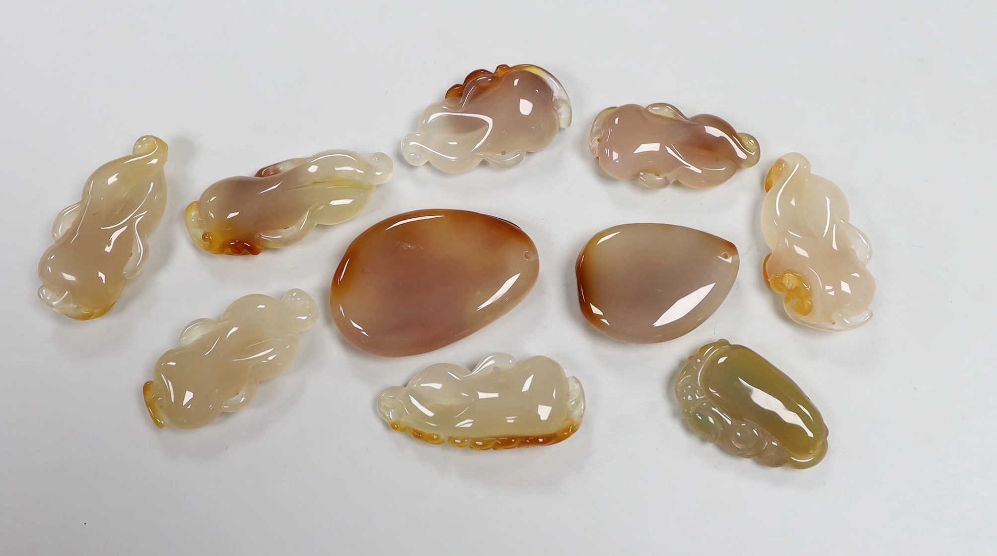 Ten Chinese agate carved pendants, the largest 6cm wide